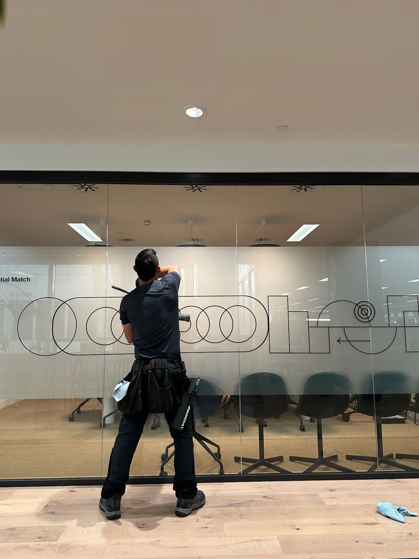 Cleaning interior office glass partitions by hand.